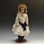 A late 19th/ early 20th century bisque shoulder doll, fixed brown eyes, open mouth, brown wig,