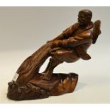 A Chinese hardwood carving of a Fisherman hauling in the nets, 25cm high,
