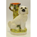 A late 19th century Staffordshire dog, seated by a tree bough, seated to the left, c.