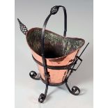 An Arts and Crafts style copper and wrought iron helmet shaped coal bucket