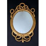 A 19th century giltwood and gesso oval looking glass, tassel cresting and apron, rope-twist border,
