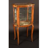 A 19th century Louis XV Revival gilt metal mounted serpentine room centre vitrine, oversailing top,