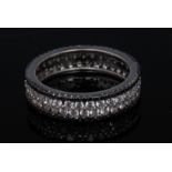 A black and white diamond eternity ring, central rows of offset round brilliant cut diamonds,