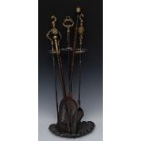 A late 19th century steel and brass three-piece fireside set, comprising sand, tongs and shovel,