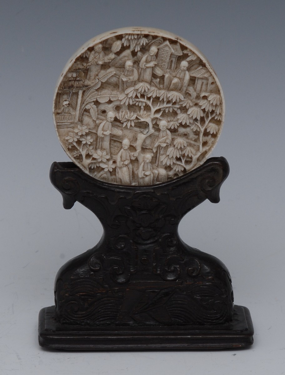 A Cantonese ivory roundel, carved in relief with figures amongst pagodas and blossoming prunus, 6.