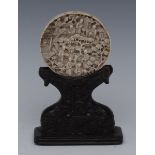 A Cantonese ivory roundel, carved in relief with figures amongst pagodas and blossoming prunus, 6.