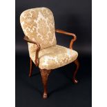 A George I style walnut elbow chair, arched back, serpentine arms, stuffed-over upholstery,