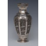 A South East Asian silver octagonal panelled vase, possibly Vietnamese, well chased with figures,