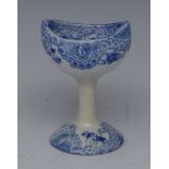 An English pottery blue and white eye bath, printed with scrolling foliage, 7cm high, c.