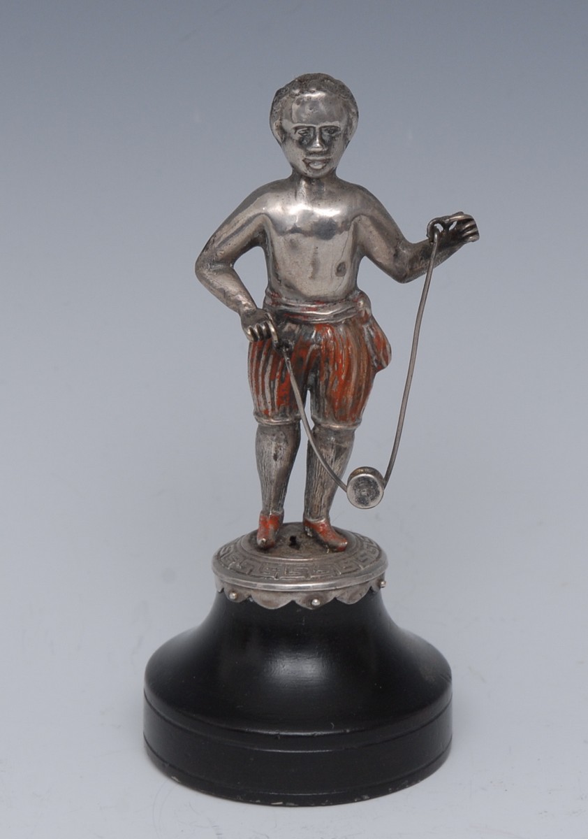 A 19th century silver coloured metal miniature figure, of a scantily clad boy playing with a diablo,