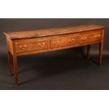 A George III oak low dresser, slightly oversailing top above three drawers, brass swan neck handles,