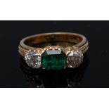 A diamond and emerald three stone ring, central baguette cut emerald, approx. 1.