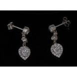 A pair of diamond teardrop earrings, each with a central inverted teardrop diamond,