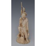 A Japanese ivory okimono, carved as a cormorant fisherman, he stands, holding his catch, 16cm high,