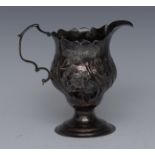 A George III Rococo silver baluster cream jug, embossed with a scrolling cartouche,