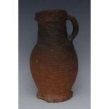 An English 13th century terracotta ribbed stoneware flagon, loop handle, crimped foot,