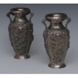 A pair of Chinese silver two handled vases, embossed with dragons,