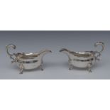 A pair of George II silver sauce boats, acanthus capped flying scroll handles, wavy borders,