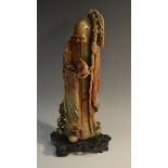 A 19th century Chinese soapstone figure, carved as Shou-Lao holding a ripe peach, hardwood base,