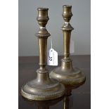 A pair of 18th century brass table candlesticks, of seamed construction, tapered stems,