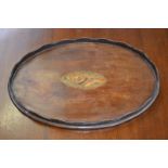 An Edwardian mahogany oval waiter or small tray, of George III design,