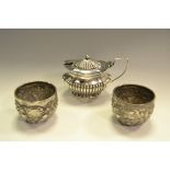 A pair of Victorian silver circular salts, chased with flowers and scrolling leaves,