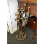 A late 19th century steel and brass three-piece fireside set, comprising stand, tongs and shovel,