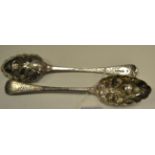 A pair of silver Old English pattern berry spoons, engraved and chased with scrolling foliage,