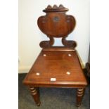 A Victorian mahogany hall chair, shaped back carved with crest, squared seat, turned legs, c.1860.