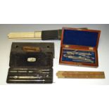 A late Victorian mahogany drawing instrument box; a slide rule; a folding boxwood ruler;