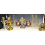 A brass oil lamp; another chronium plated; a pair of copper oil wall lamps; oil lamp chimneys ;