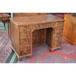 A George III flame mahogany kneehole desk, oversailing top,