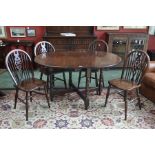 An oak Jaycee D-end gateleg table and four wheel back chairs.
