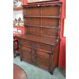 A Jaycee dark oak dresser, two shelves to top, shaped uprights,