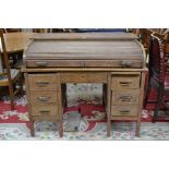 An early 20th century oak roll top desk