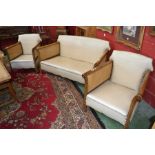 An early 20th century oak Bergere three piece suite