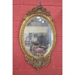 A three light oval gilt girandole mirror,