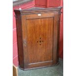 A George III oak splay fronted corner cabinet, c.