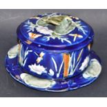 A Majolica cheese dish, bird handle decorated with butterflies,