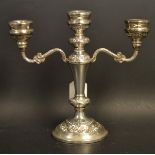 A silver two branch candelabra, cast scrolling arms, weighted base,