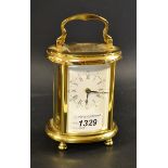 A Woodford carriage clock, white dial, Roman numerals, minute track, brass effect oval case,