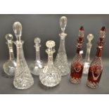 A pair of cut glass ruby decanters; other decanters.