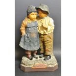 A late 19th century Dutch earthenware figural group, two children, an important secret,