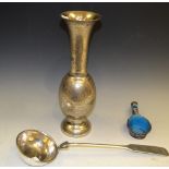 A Persian silver coloured vase; a silver coloured ladle;