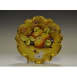 A Coalport shaped circular plates, decorated with apples, pears and berries, on a mossy ground,