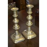 A pair of early 19th century brass candlesticks with pushers,