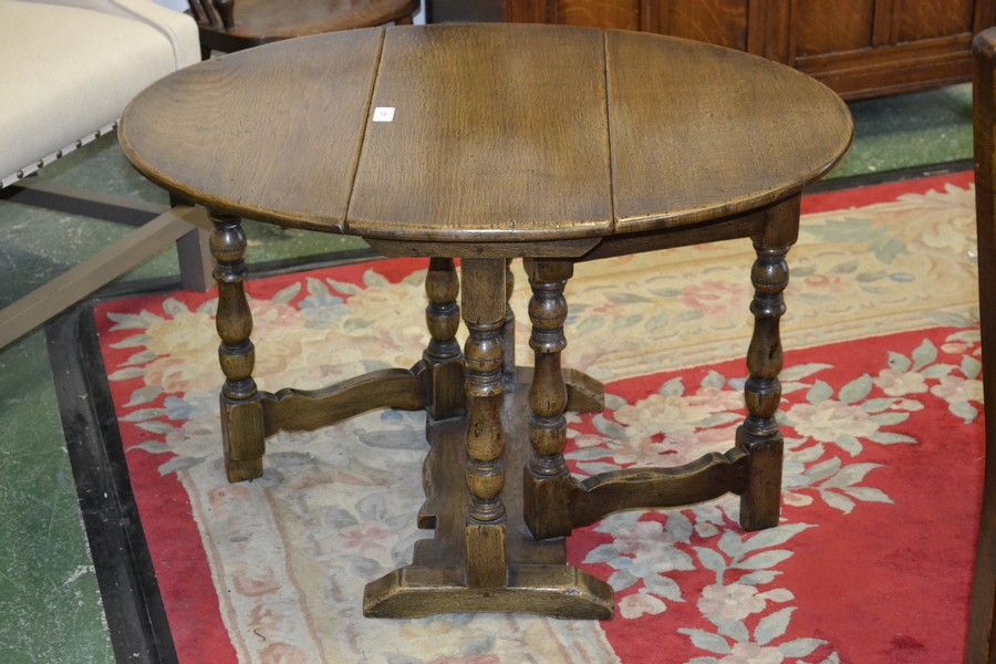 An oak dropleaf occasional table, oval top, turned supports. 51cm high x 58.