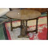 An oak dropleaf occasional table, oval top, turned supports. 51cm high x 58.