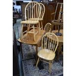 A pine dropleaf table and four spindle back elm dining chairs.