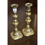 A pair of early 19th century brass candlesticks with pushers,